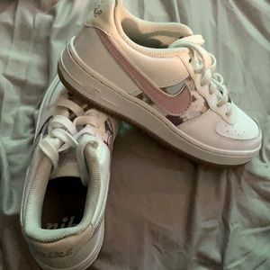Air 1s (Big Kids) Pink swoosh with floral pattern.